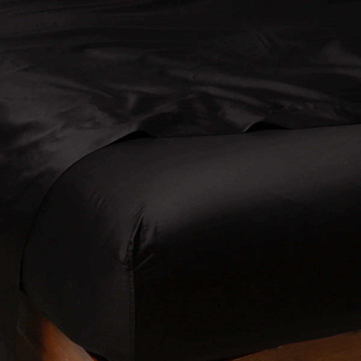 Corvino: Cotton sateen fitted sheet shown from the top corner, highlighting the shine of the fabric.