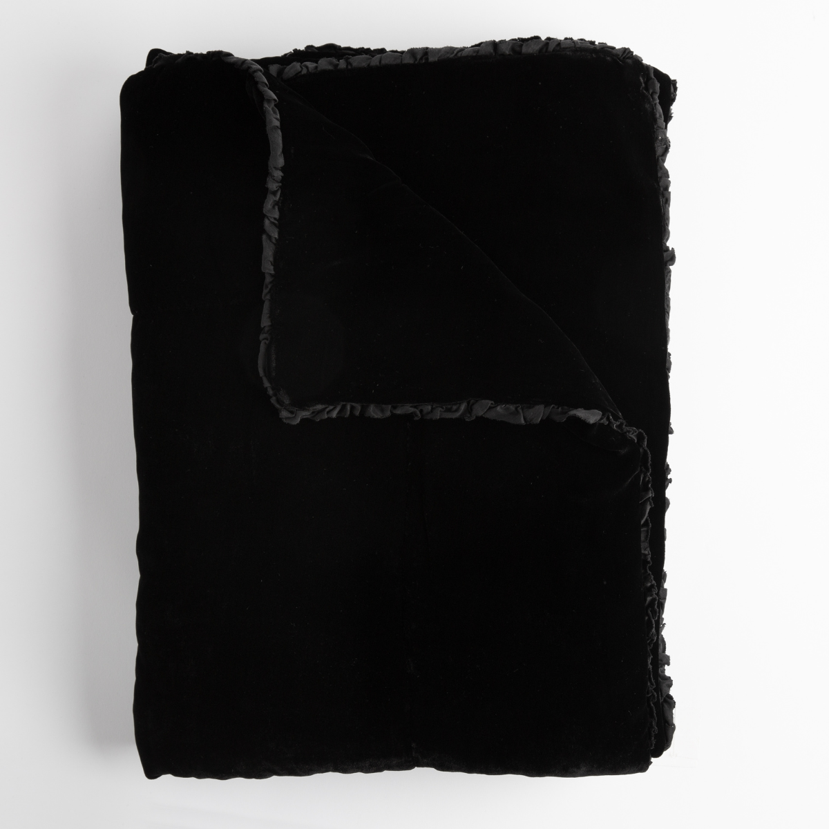 Corvino: silk velvet bed end sized throw blanket shown folded with corner folded down to show trim detail — shown from overhead on a white background.