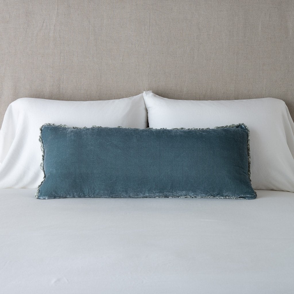 Mineral: Silk velvet lumbar pillow with petite ruffle, leaning upright against neutral bedding and headboard.