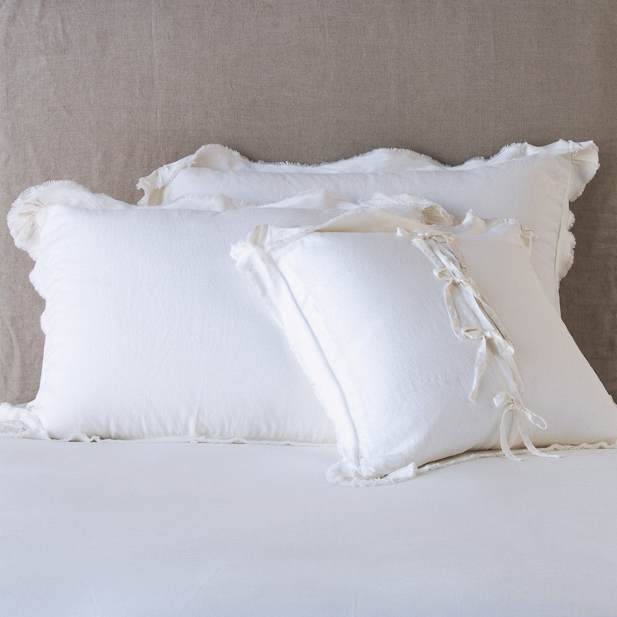 Winter White: satin trimmed linen shams showing the front and back of the sham with tie closures. 