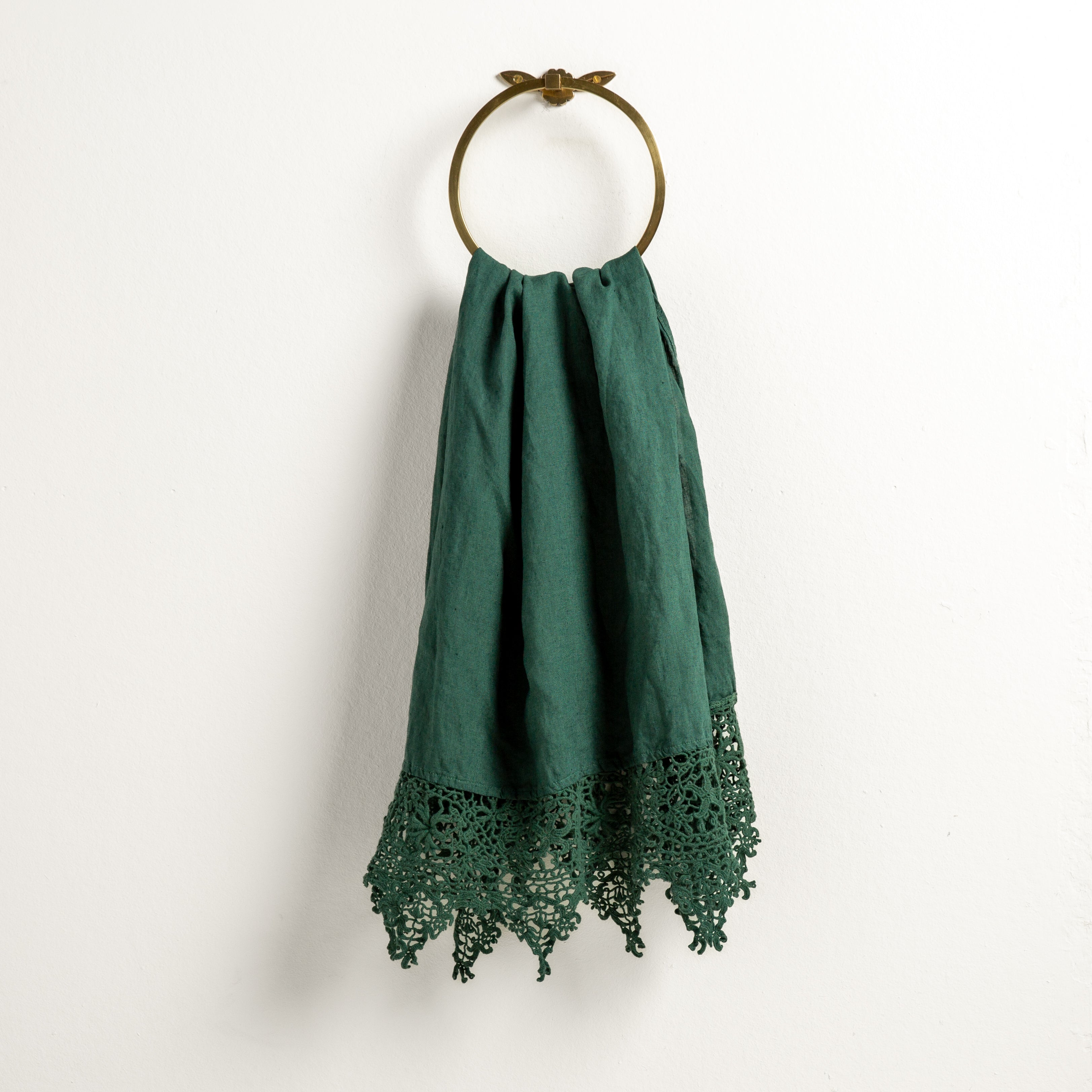 Jade: Lace trimmed linen guest towel  draped through a decorative towel ring against a plain white background.