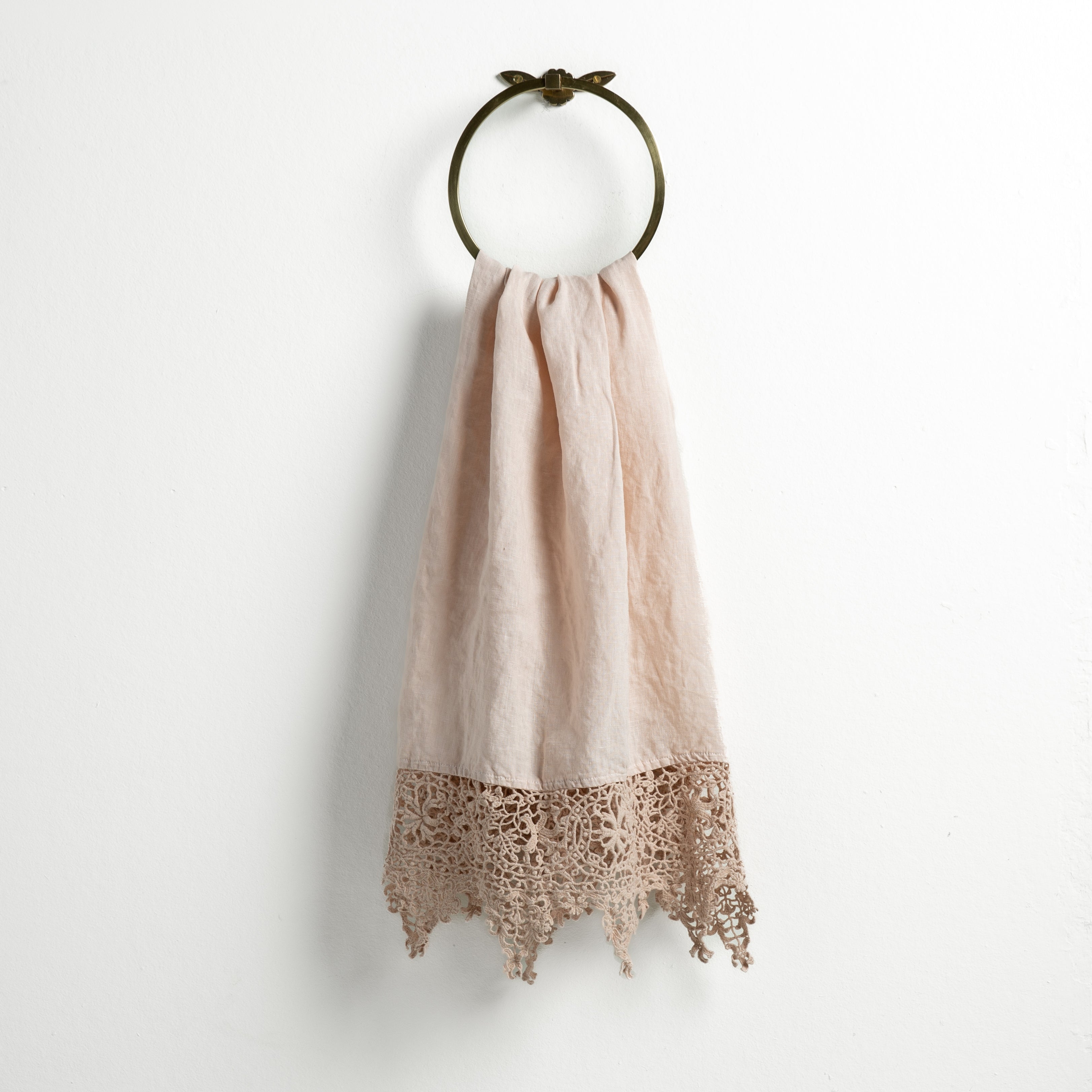 Pearl: Lace trimmed linen guest towel  draped through a decorative towel ring against a plain white background.