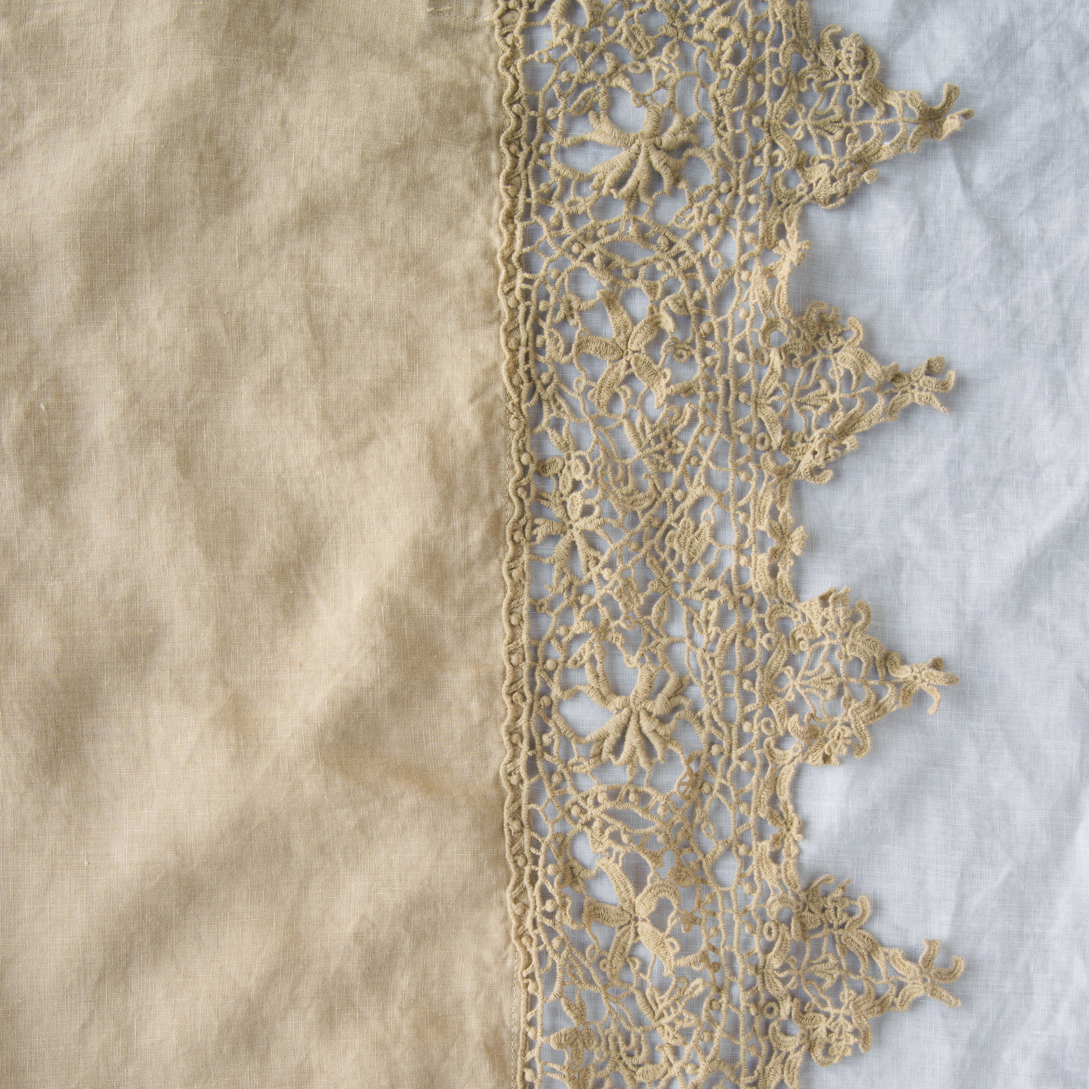 Honeycomb: A close up of Frida, an antique cotton lace trim on a linen body, shown in honeycomb, a warm golden tone.