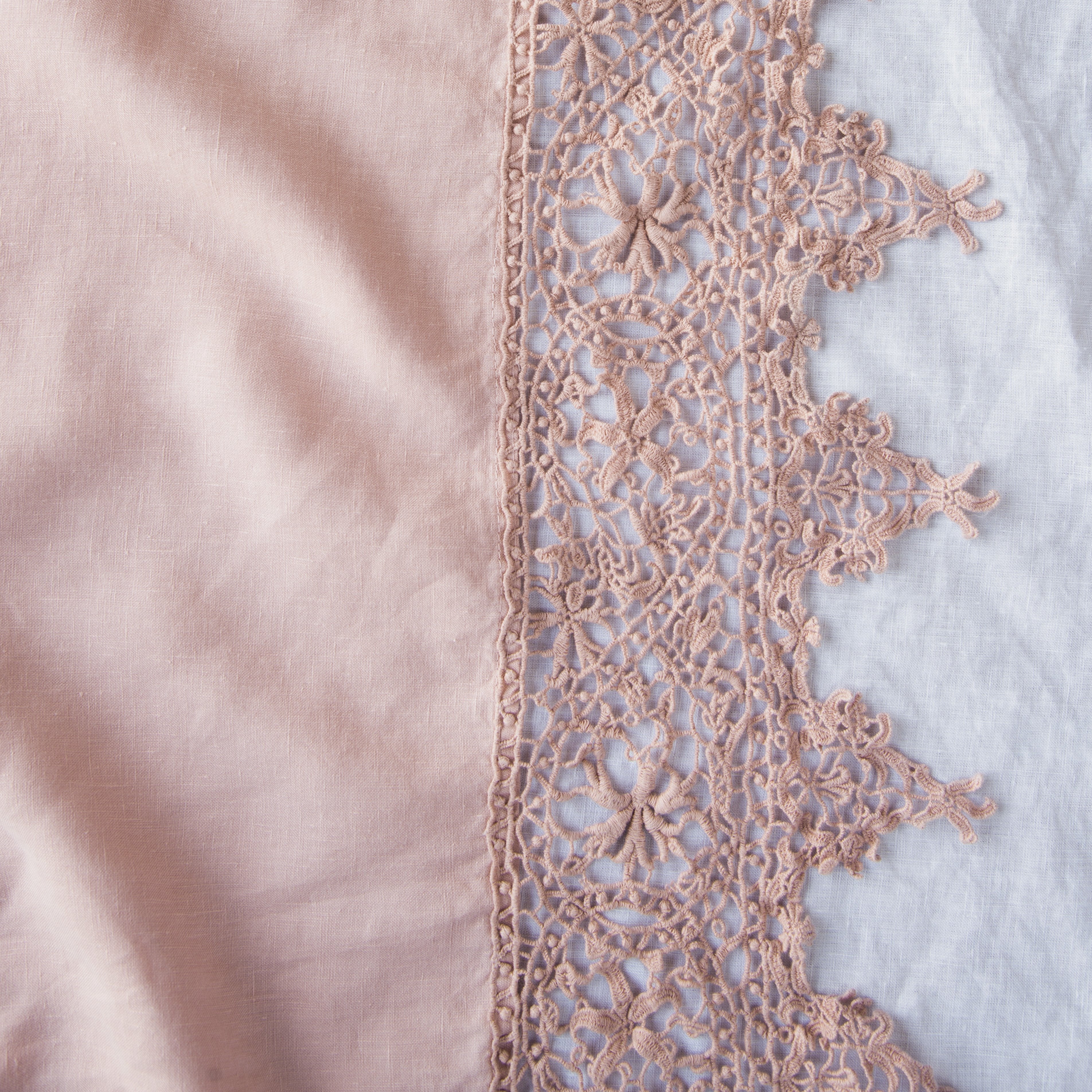 Rouge: A close up of Frida, an antique cotton lace trim on a linen body, shown in rouge, a mid-tone blush pink.