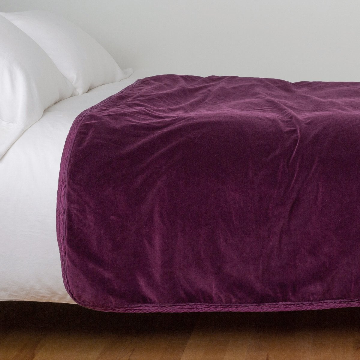 Fig: Cotton velvet bed end sized  blanket, draped on a white bed - side view.