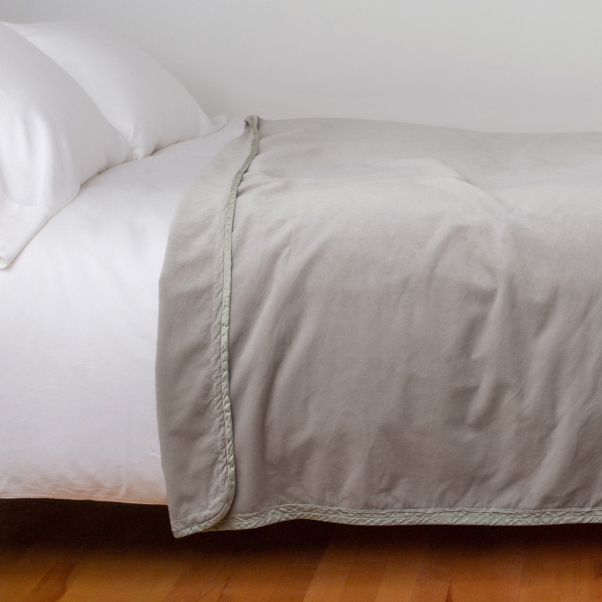 Fog: Cotton velvet blanket, draped on a white bed with corner folded back - side view.