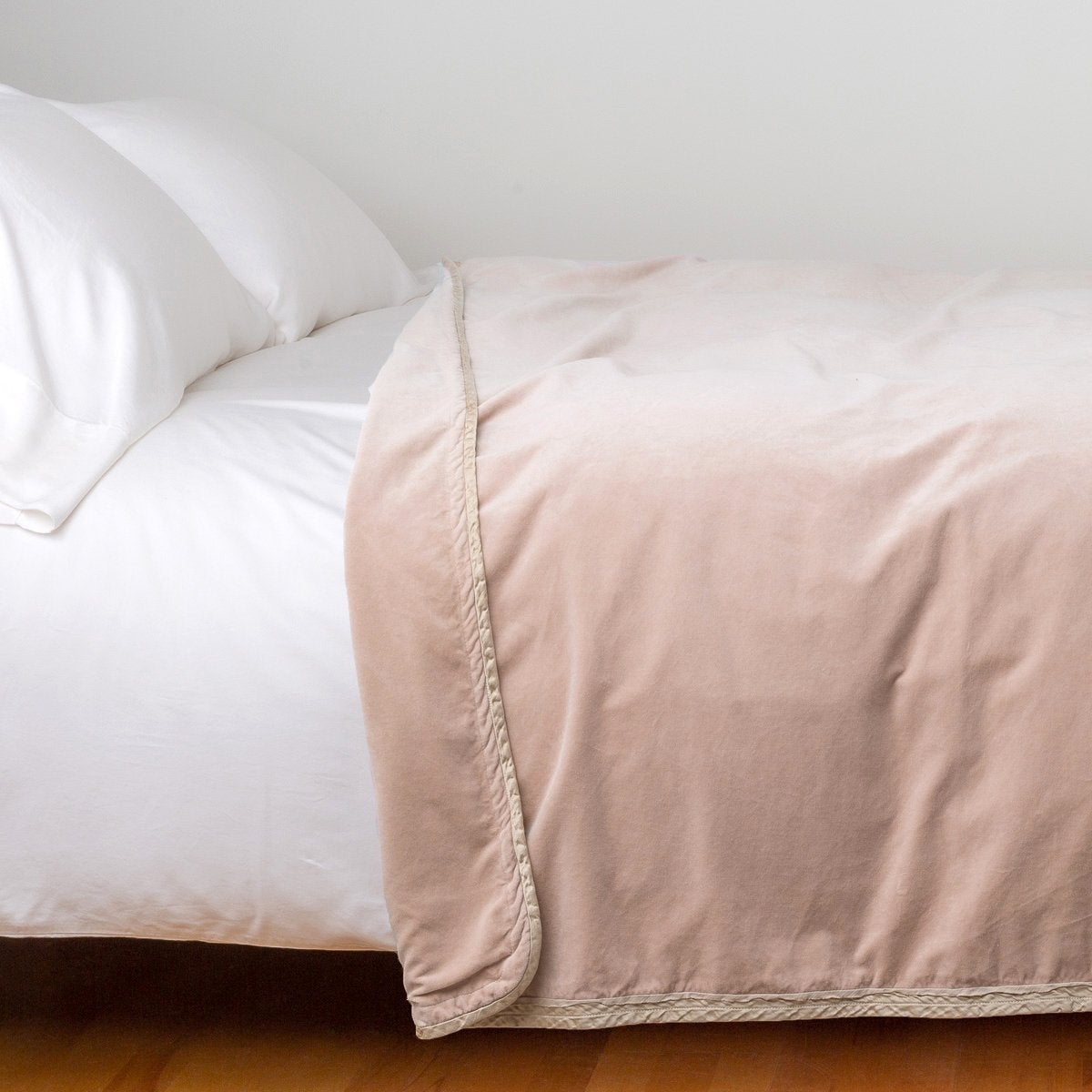 Pearl: Cotton velvet blanket, draped on a white bed with corner folded back - side view.