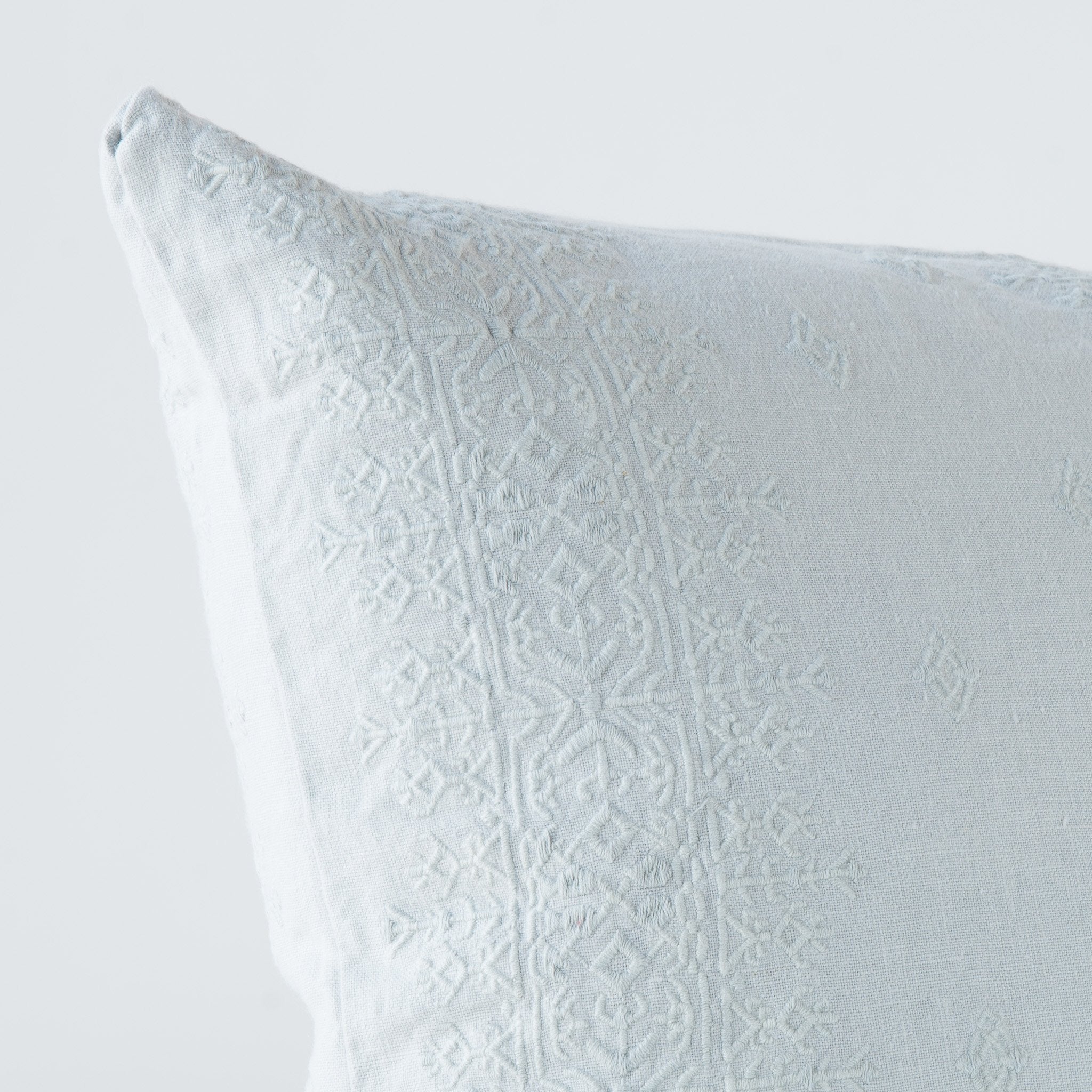 Cloud: Close-up of pillow corner, showcasing the embroidery pattern detail.