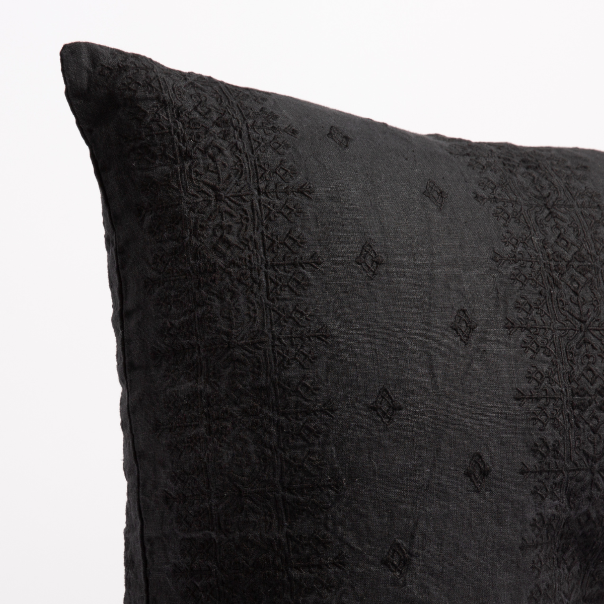 Corvino: Close-up of pillow corner, showcasing the embroidery pattern detail.