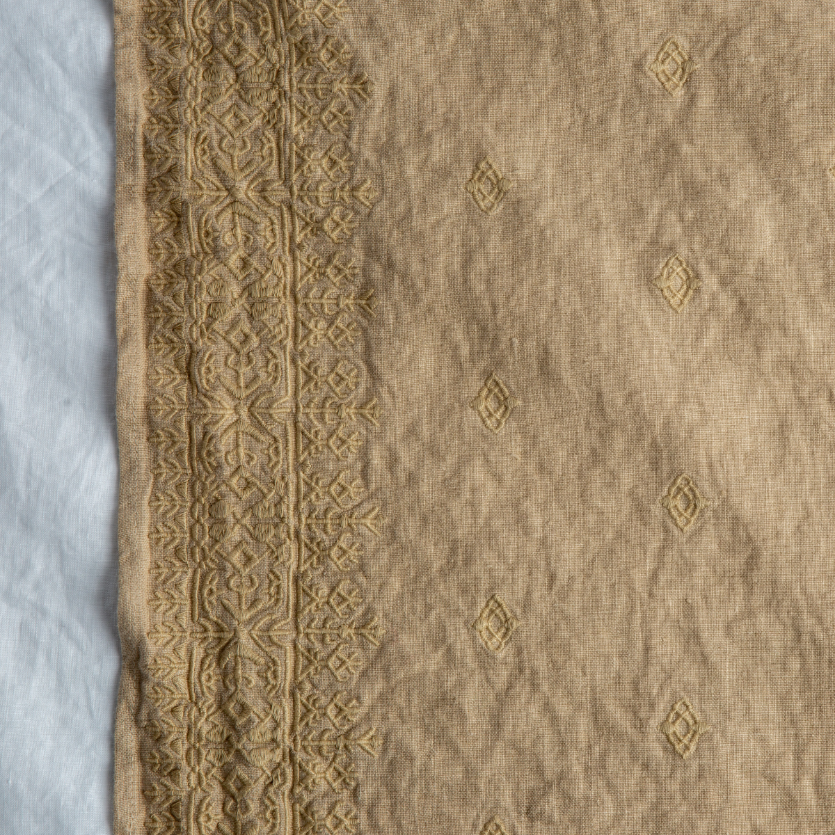 Honeycomb: A close up of Ines, midweight linen with cotton embroidery, in white.