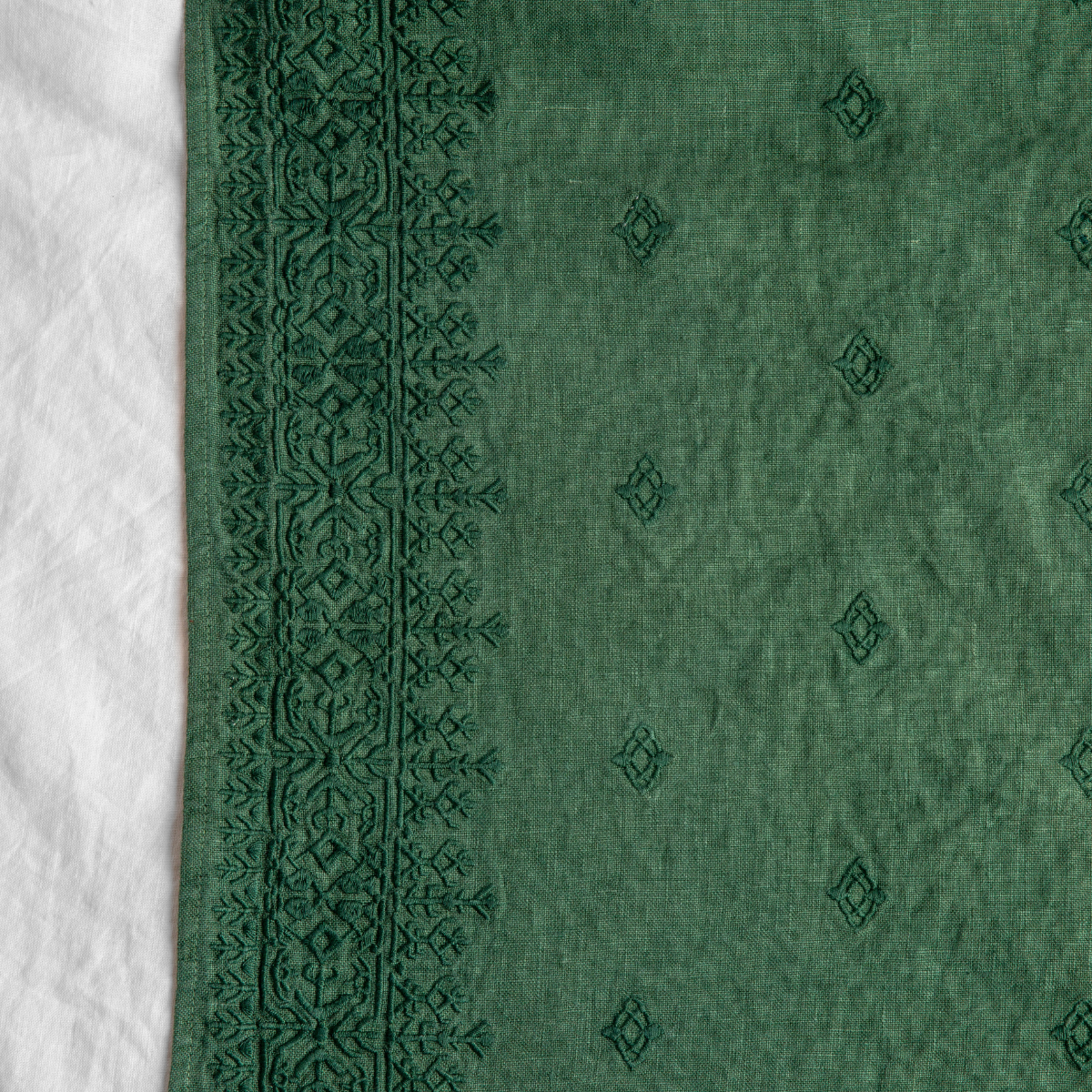 Jade: A close up of Ines, midweight linen with cotton embroidery, in white.