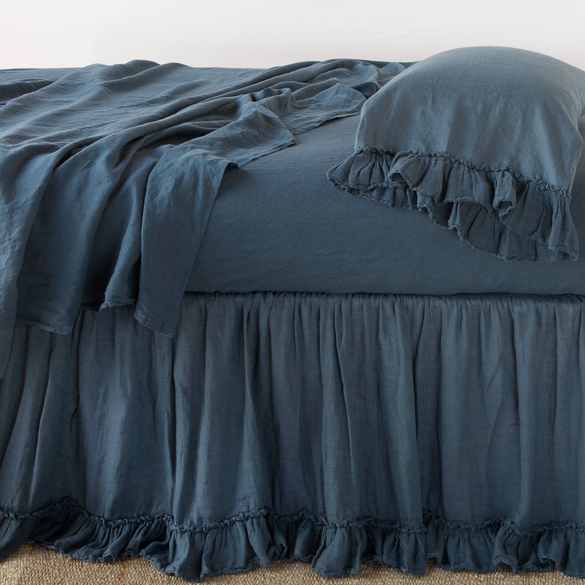 Midnight: bed skirt layered with monochromatic linen sheeting - side view.