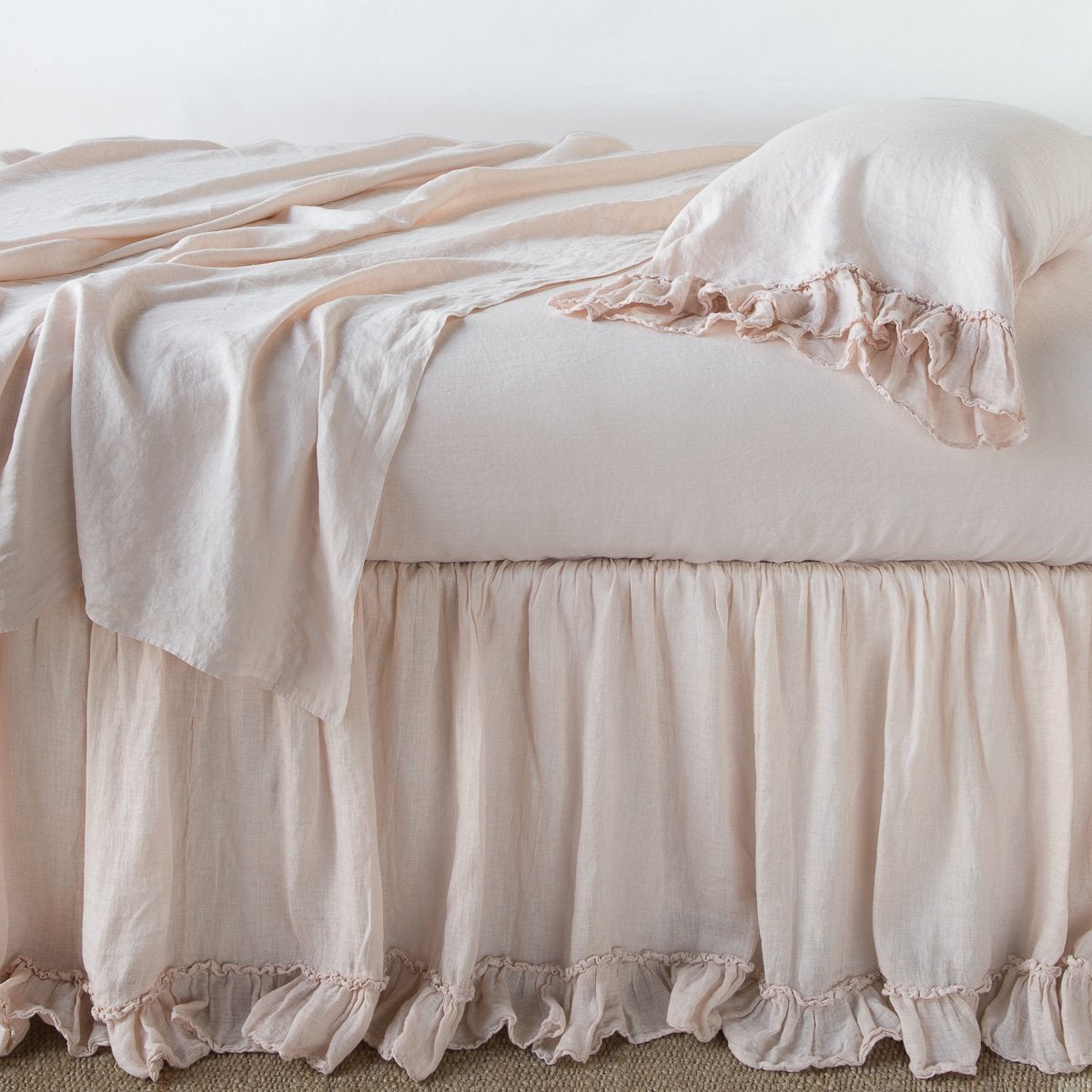 Pearl: bed skirt layered with monochromatic linen sheeting - side view.