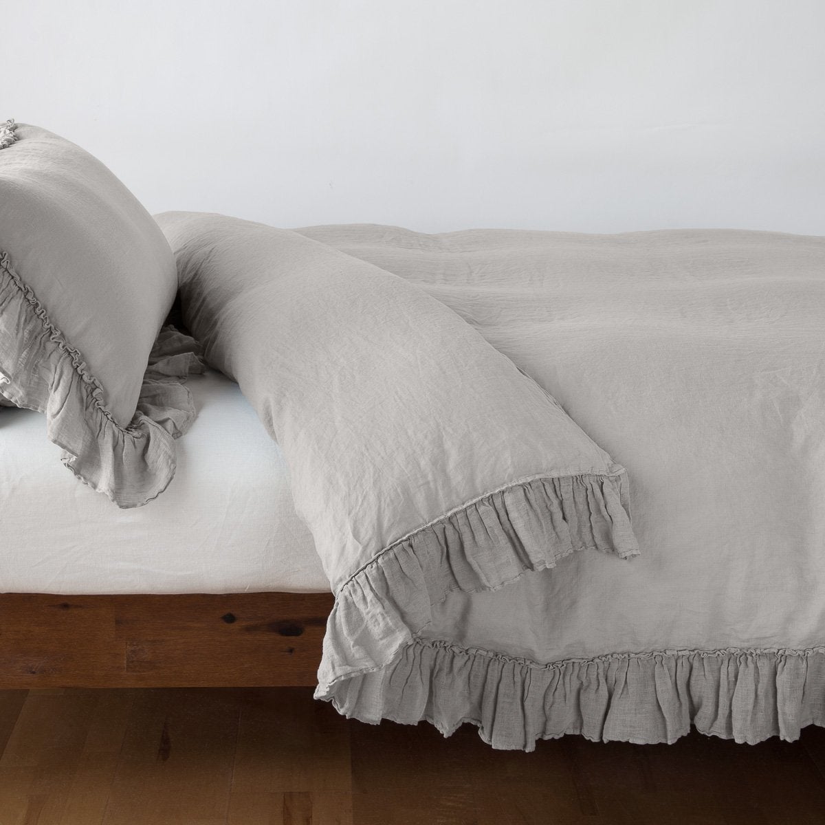 Fog: duvet cover folded back over a white fitted sheet, shown with matching sham against a plain background - side view.