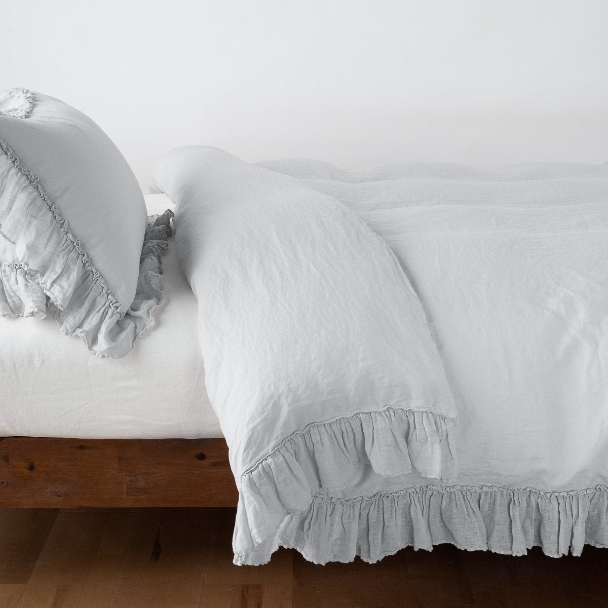 Sterling: duvet cover folded back over a white fitted sheet, shown with matching sham against a plain background - side view.