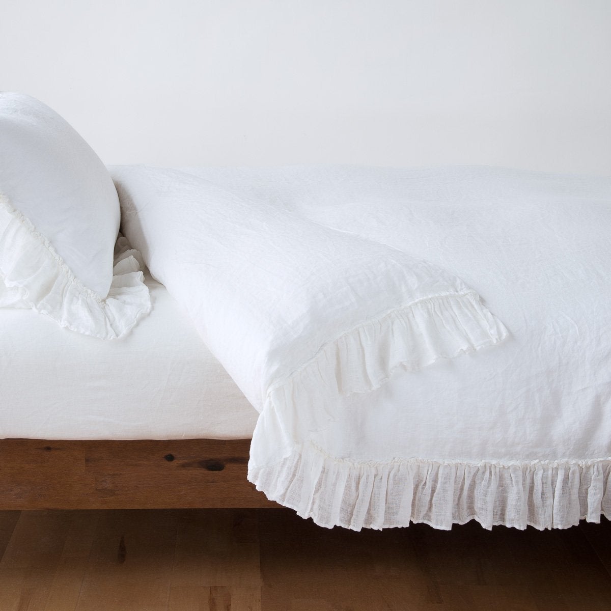 White: duvet cover folded back over a white fitted sheet, shown with matching sham against a plain background - side view.
