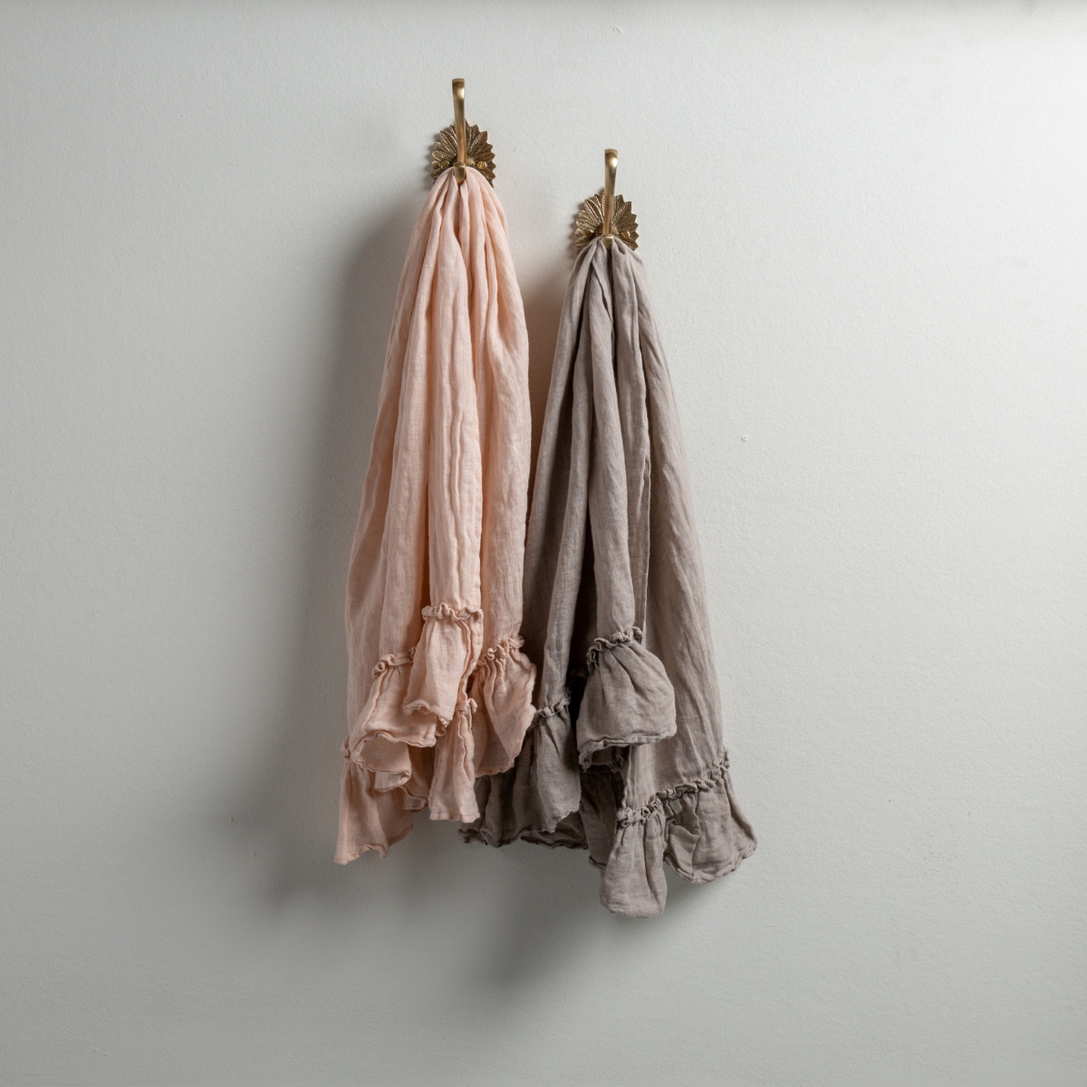 [allvariants]: Two Linen Whisper guest towels, draped over decorative hooks against a white wall - pearl and fog.