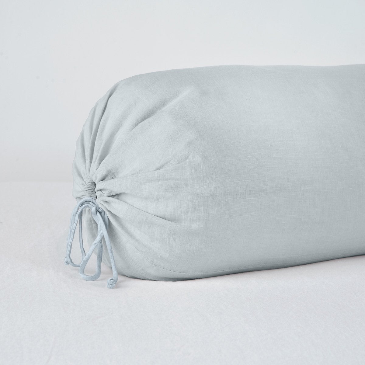 Cloud: Close-up bolster end detail, angled view to show gathered closure and satin ties.