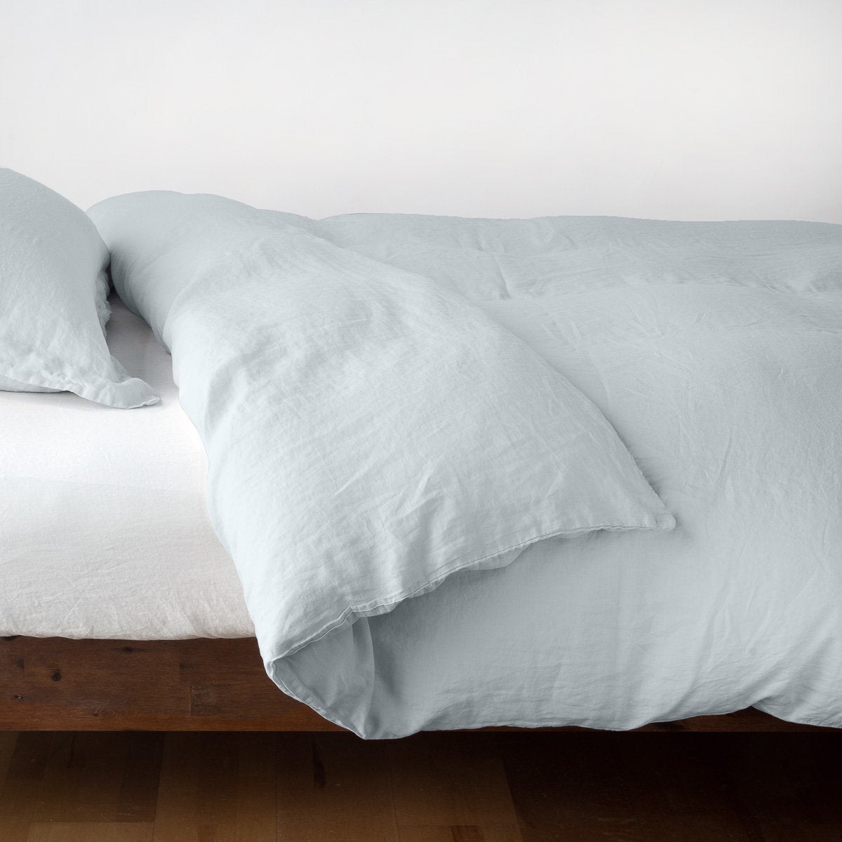 : Linen duvet cover in cloud, neatly folded back over linen sheeting -side view.