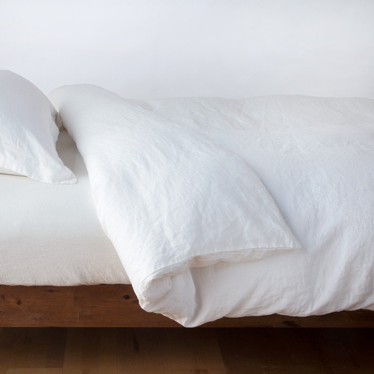 Winter White: duvet cover neatly folded back over white linen sheeting - side view.
