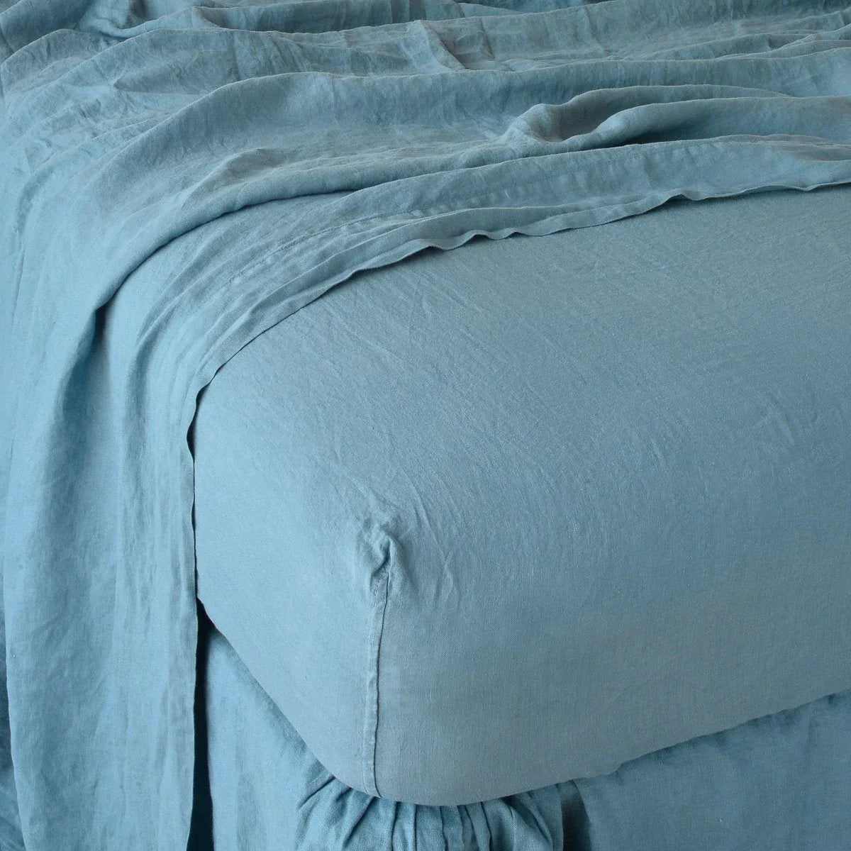 Cenote: close up of fitted sheet with matching rumpled flat sheet - corner view.