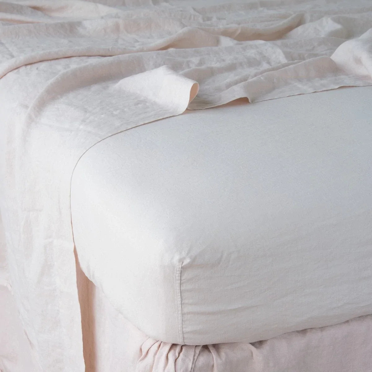 Pearl: close up of fitted sheet with matching rumpled flat sheet - corner view.