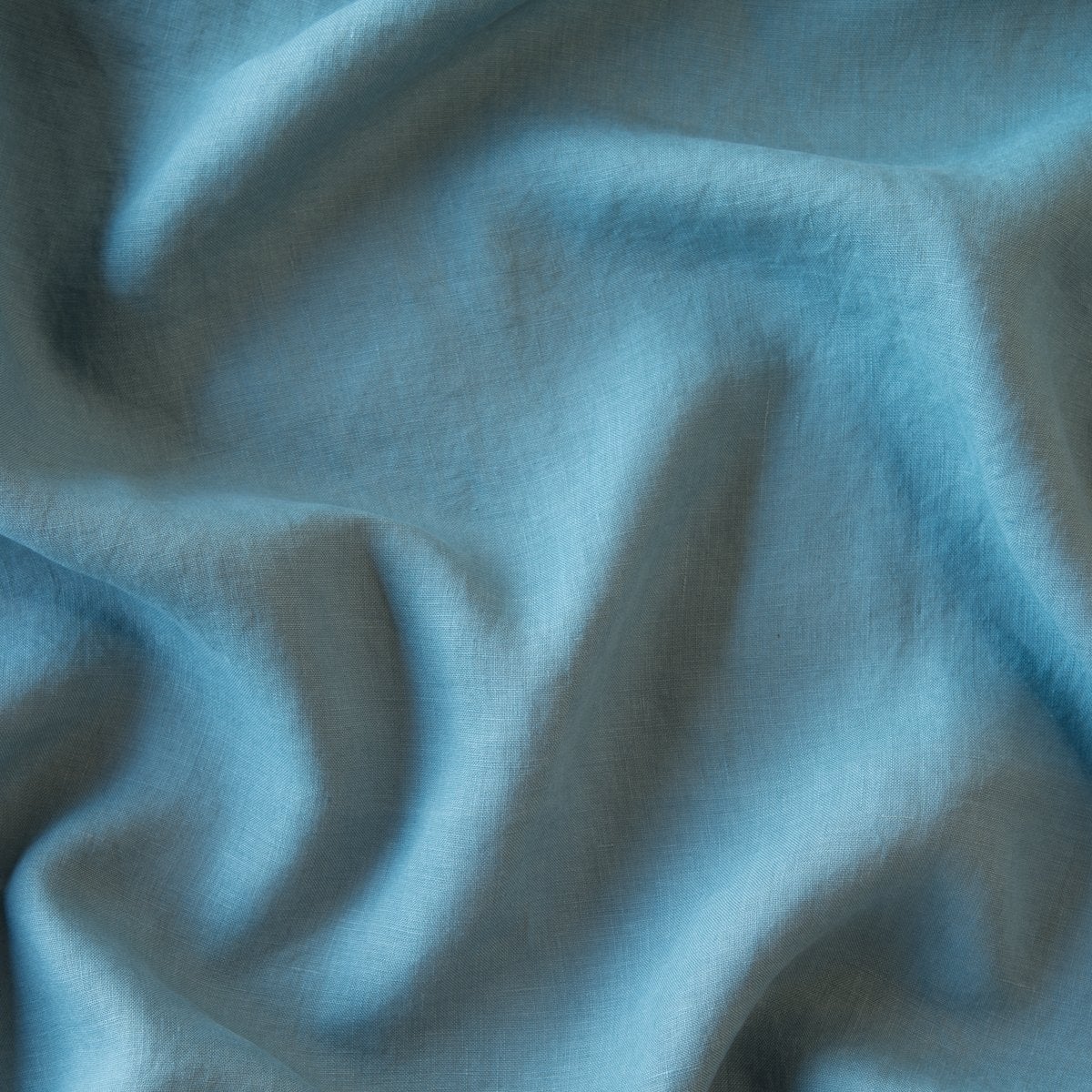 Cenote: A close up of linen in cenote, a vibrant, ocean-inspired blue-green.