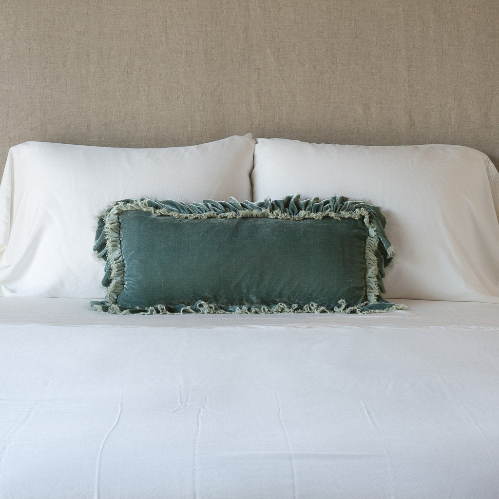 Eucalyptus: pillow on a white bed - cropped end of bed view.