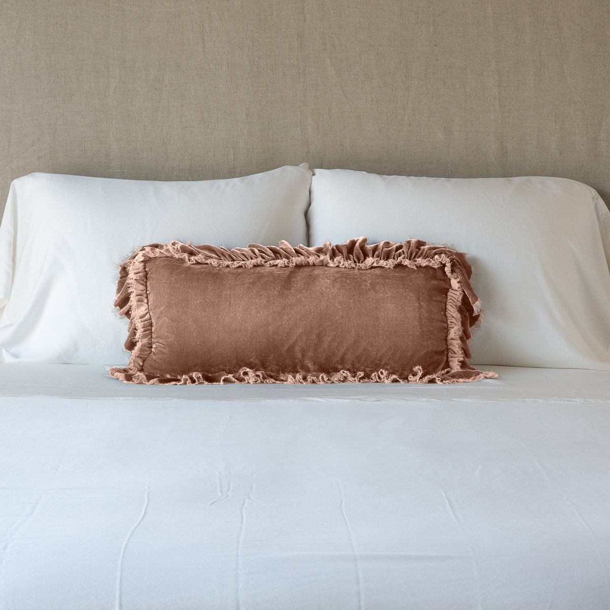 Rouge: pillow on a white bed - cropped end of bed view.