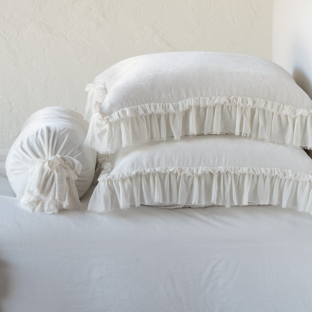 Winter White: Two shams stacked flat next to matching bolster. Close-up side view highlights the ruffle trim.
