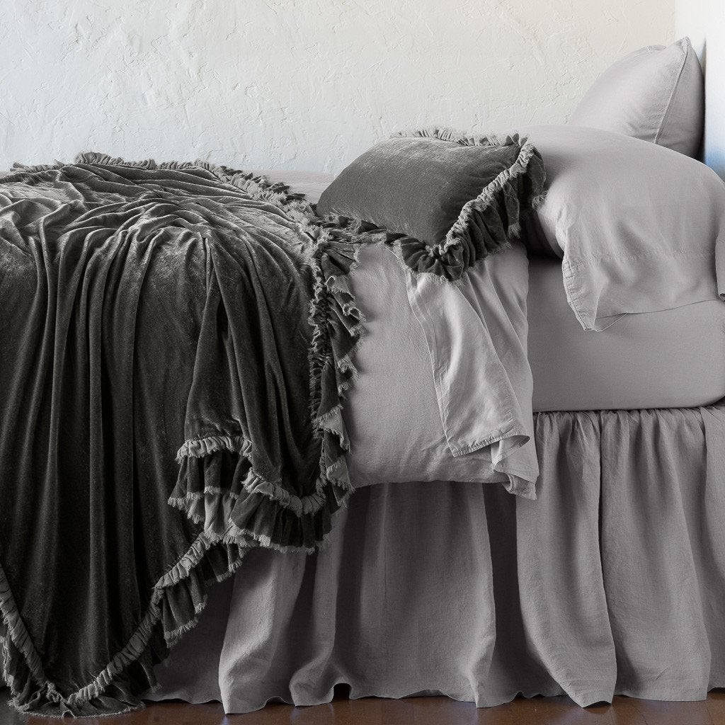 Fog: throw blanket draped over a monochromatic bed, shown with matching throw pillow - side view.