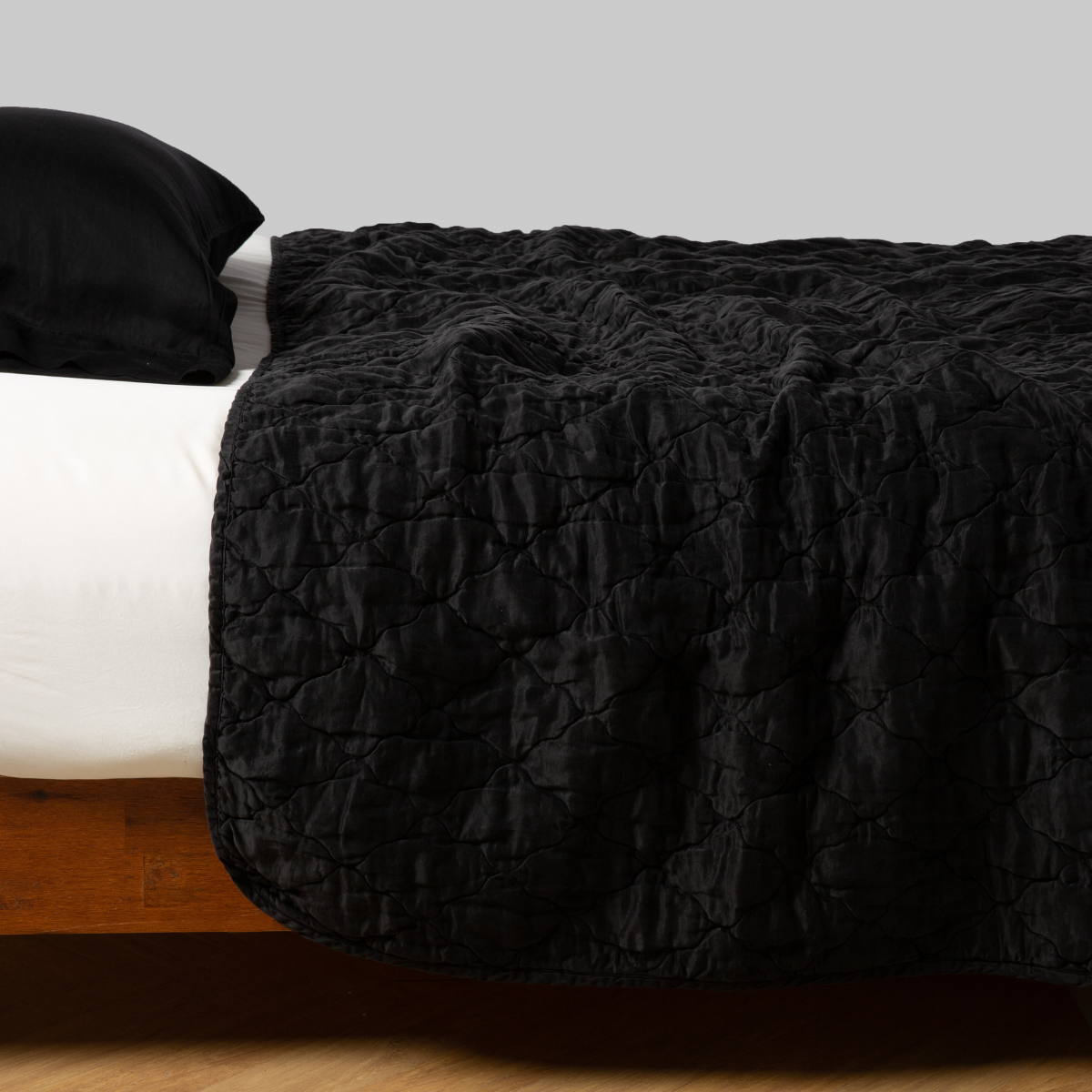 Corvino: gently rumpled coverlet on bed with white sheeting and matching pillow - side view