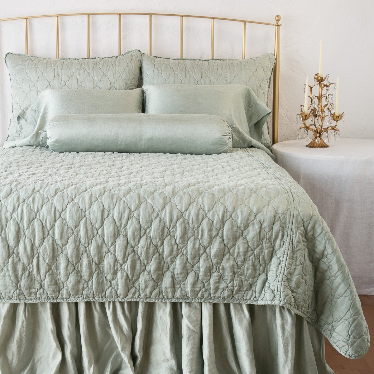 Eucalyptus: shams on a shining, monochromatic bed with matching coverlet - end of bed view.