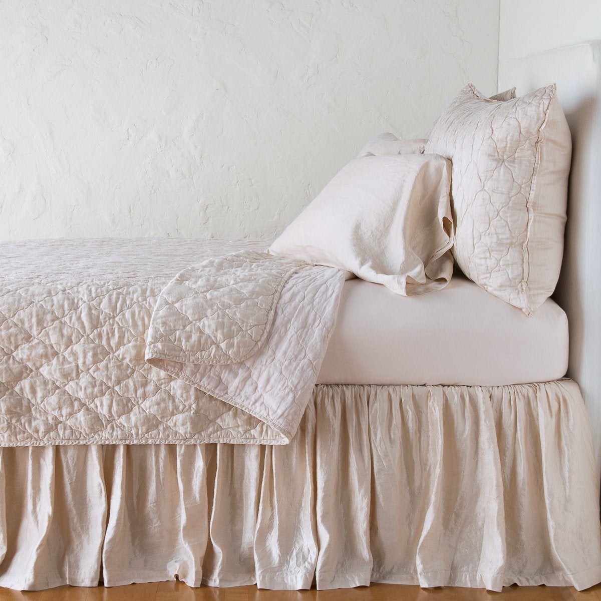 Pearl: shams with a matching coverlet pulled back over monochromatic sheeting - side view.