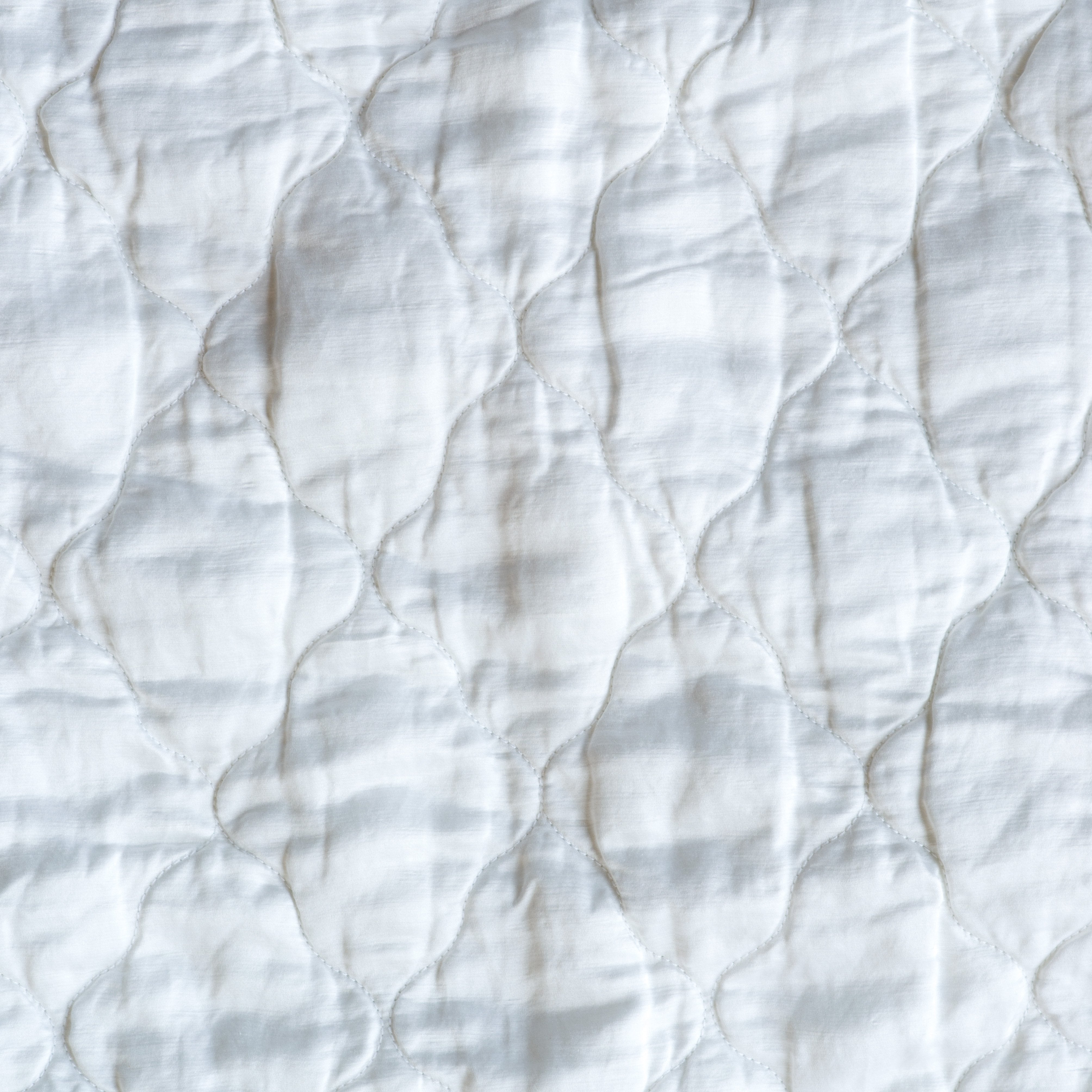 White: Close-up of Luna silk charmeuse quilting in white.