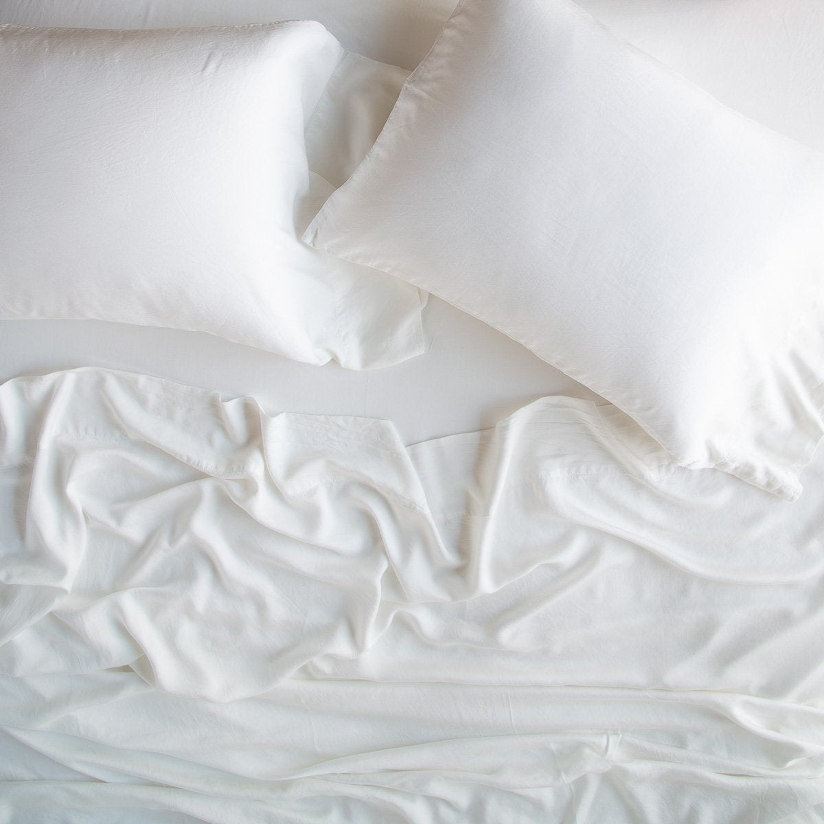 Winter White: rumpled sheeting and sleeping pillows - overhead view.