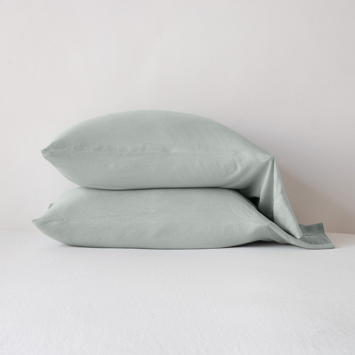 [allvariants]: Madera Luxe sleeping pillows in eucalyptus, stacked neatly against a white backdrop - side view.