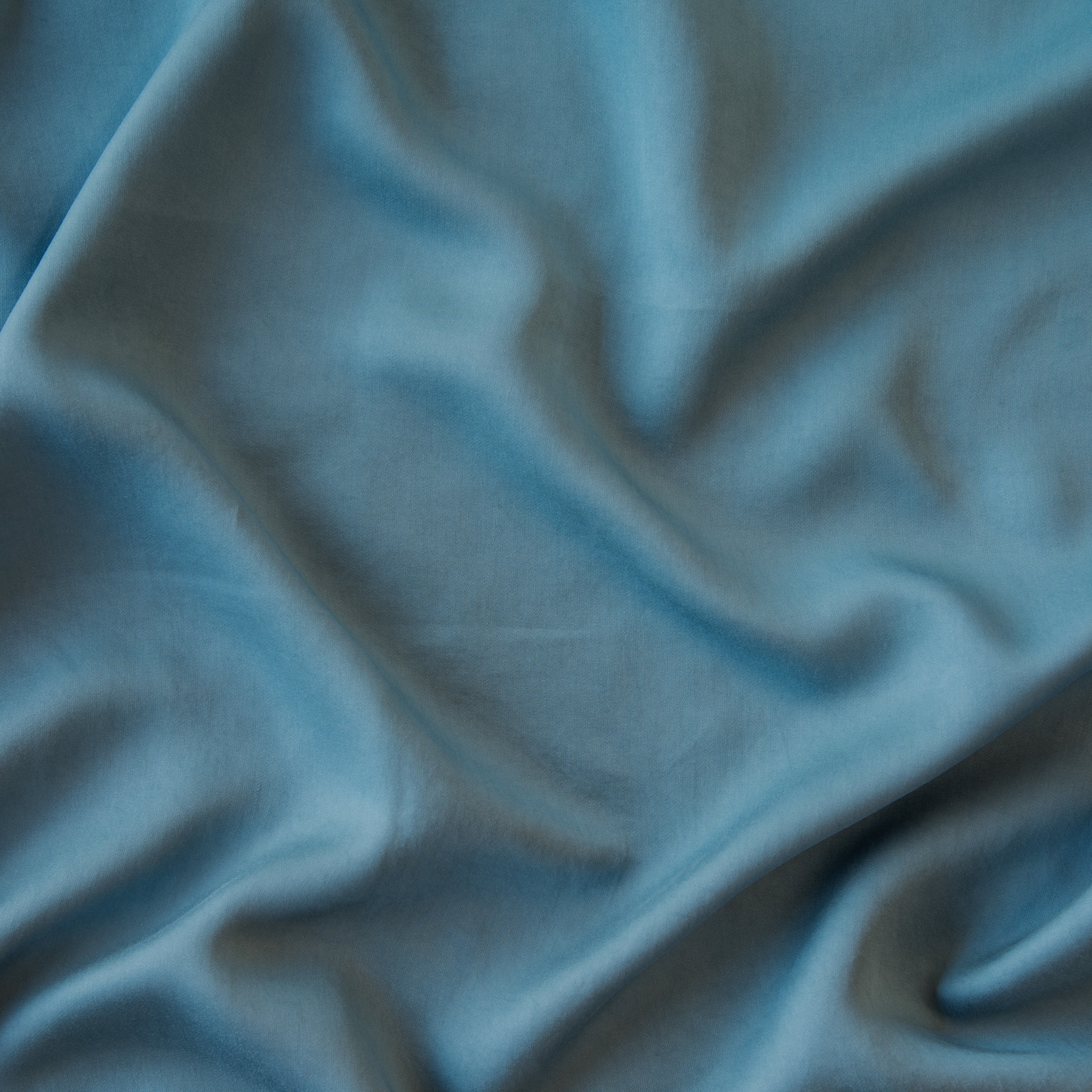 Cenote: A close up of Tencel™ in cenote, a vibrant, ocean-inspired blue-green. 