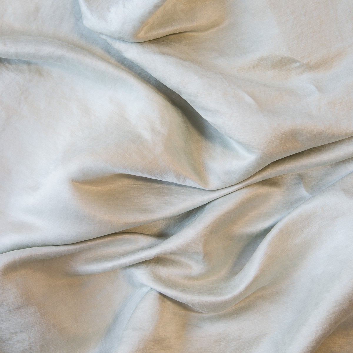 Sterling: Close-up of silk charmeuse in sterling, a silvery neutral light grey. 