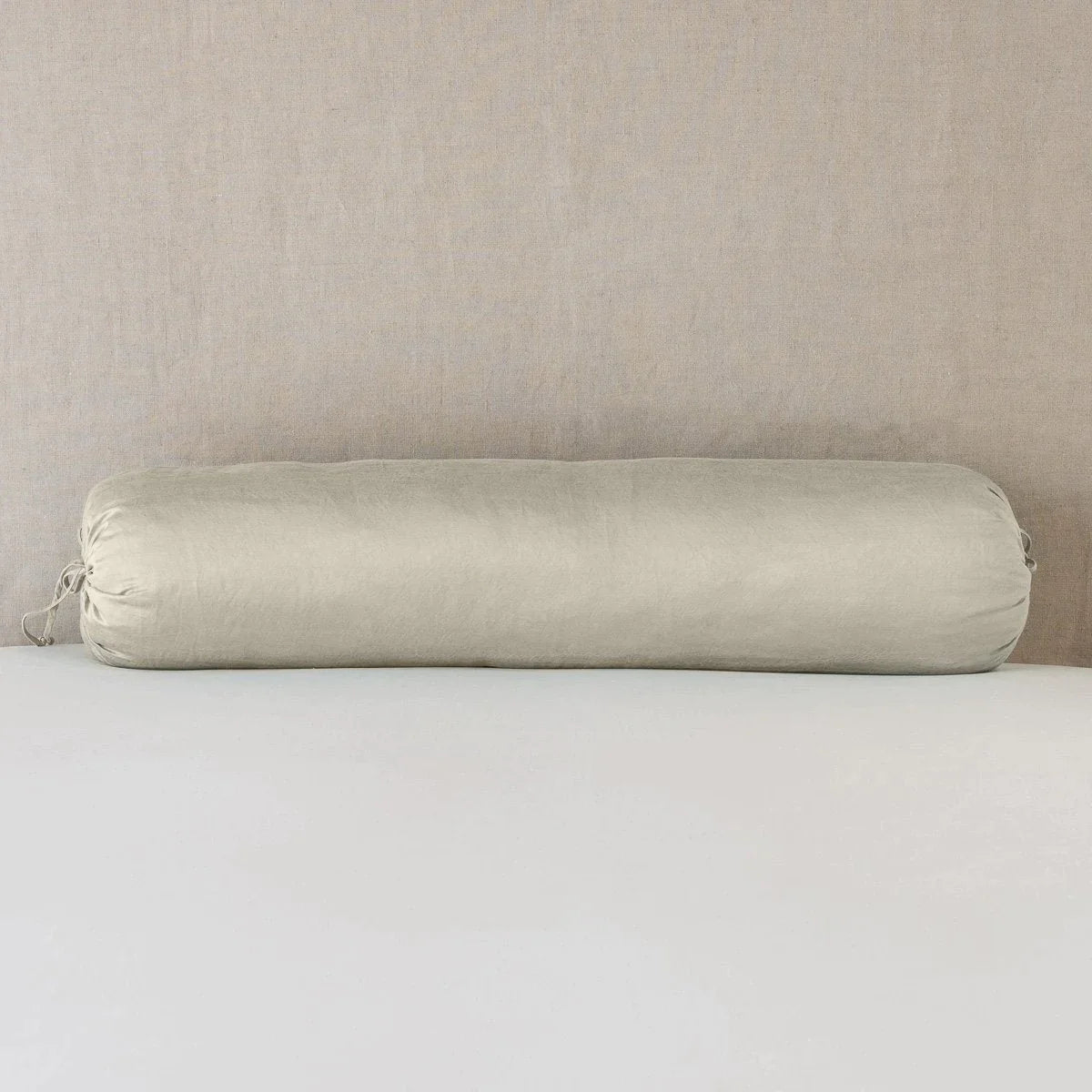 Fog: bolster on white sheets with a neutral headboard.