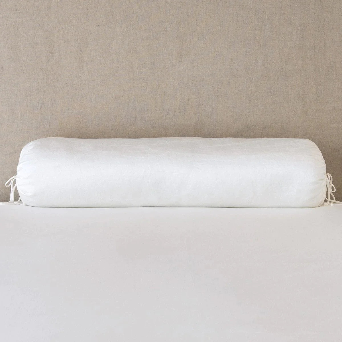 Winter White: bolster on white sheets with a neutral headboard.