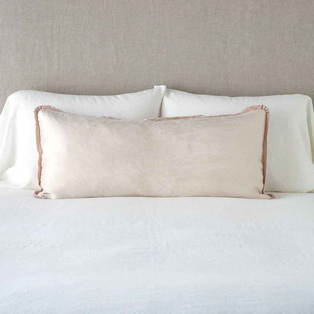 Pearl: 16x36 charmeuse pllow wth silk velvet trim against white sleeping pillows and sheets — straight on with neutral background.