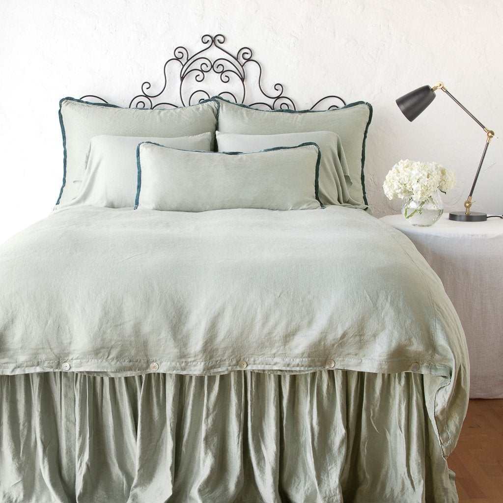 : Paloma shams on a monochromatic all charmeuse bed - eucalyptus, end of bed view.
