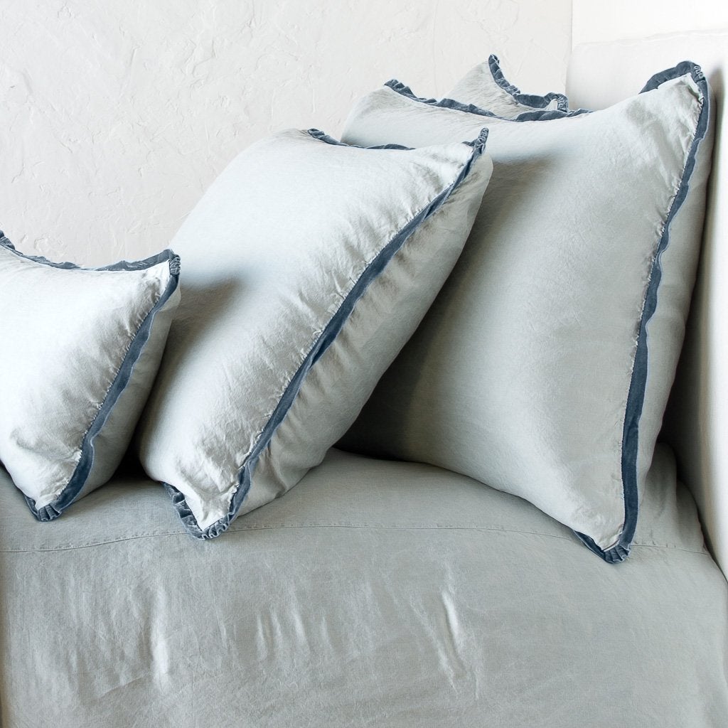 : Paloma shams and lumbar pillow on a matching duvet cover - mineral, cropped side view.