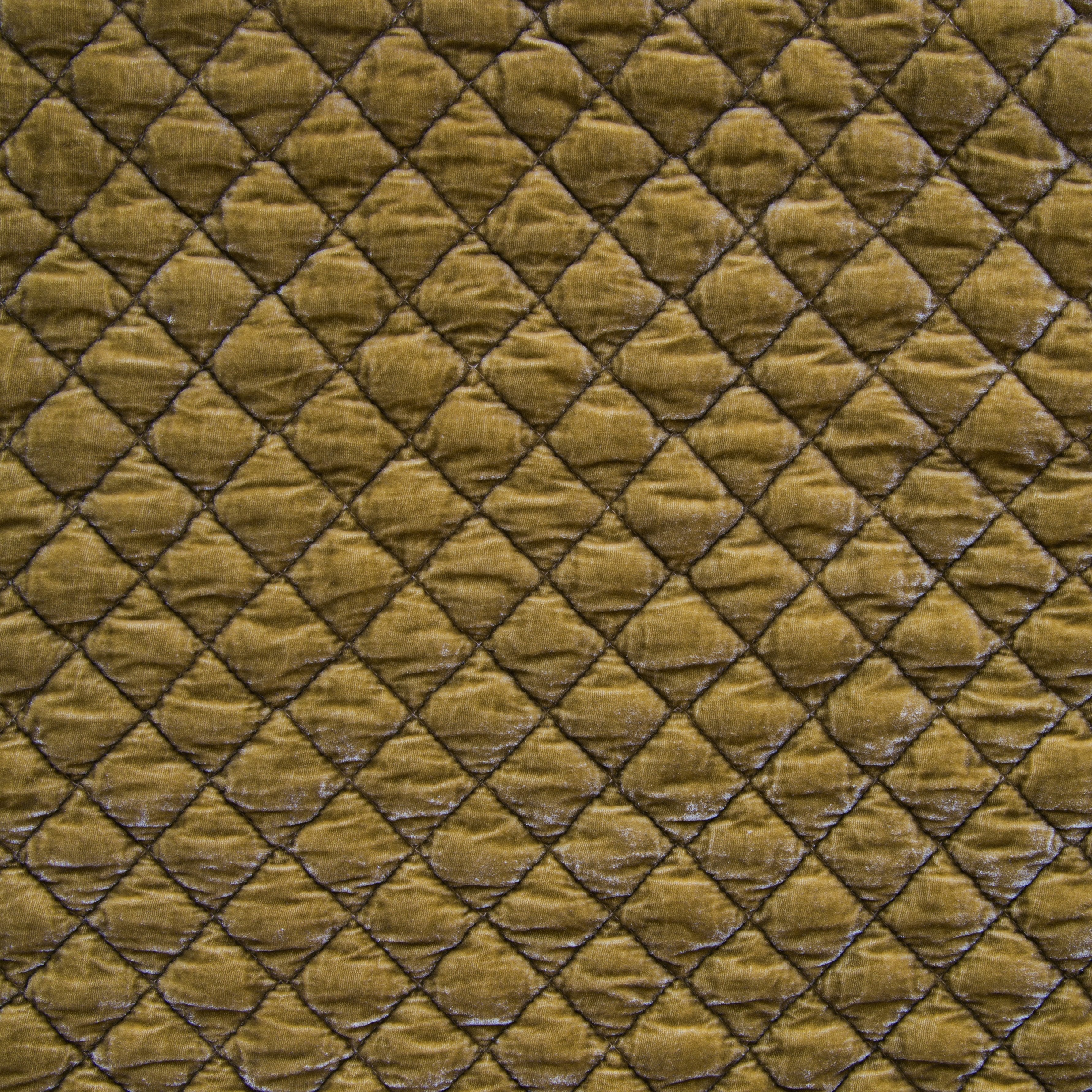 Honeycomb: Close-up of quilted silk velvet in honeycomb, a warm golden tone.