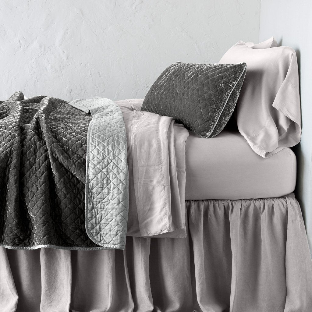 Fog: 16x36 pillow with rumpled matching coverlet on monochromatic bed - side view.
