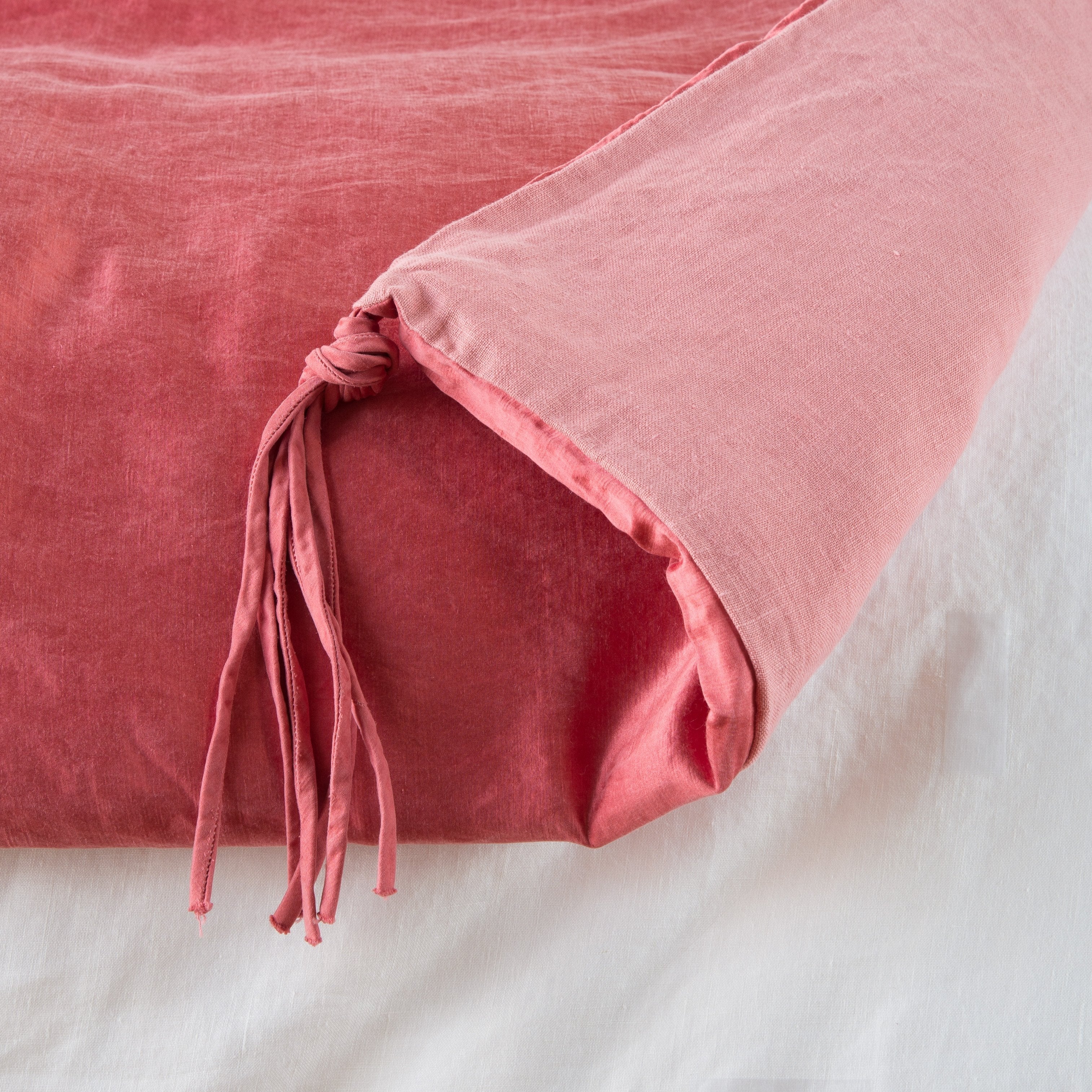 Poppy: Close up of blanket, with a corner turned back to showcase the midweight linen back and corner tassel - overhead view.