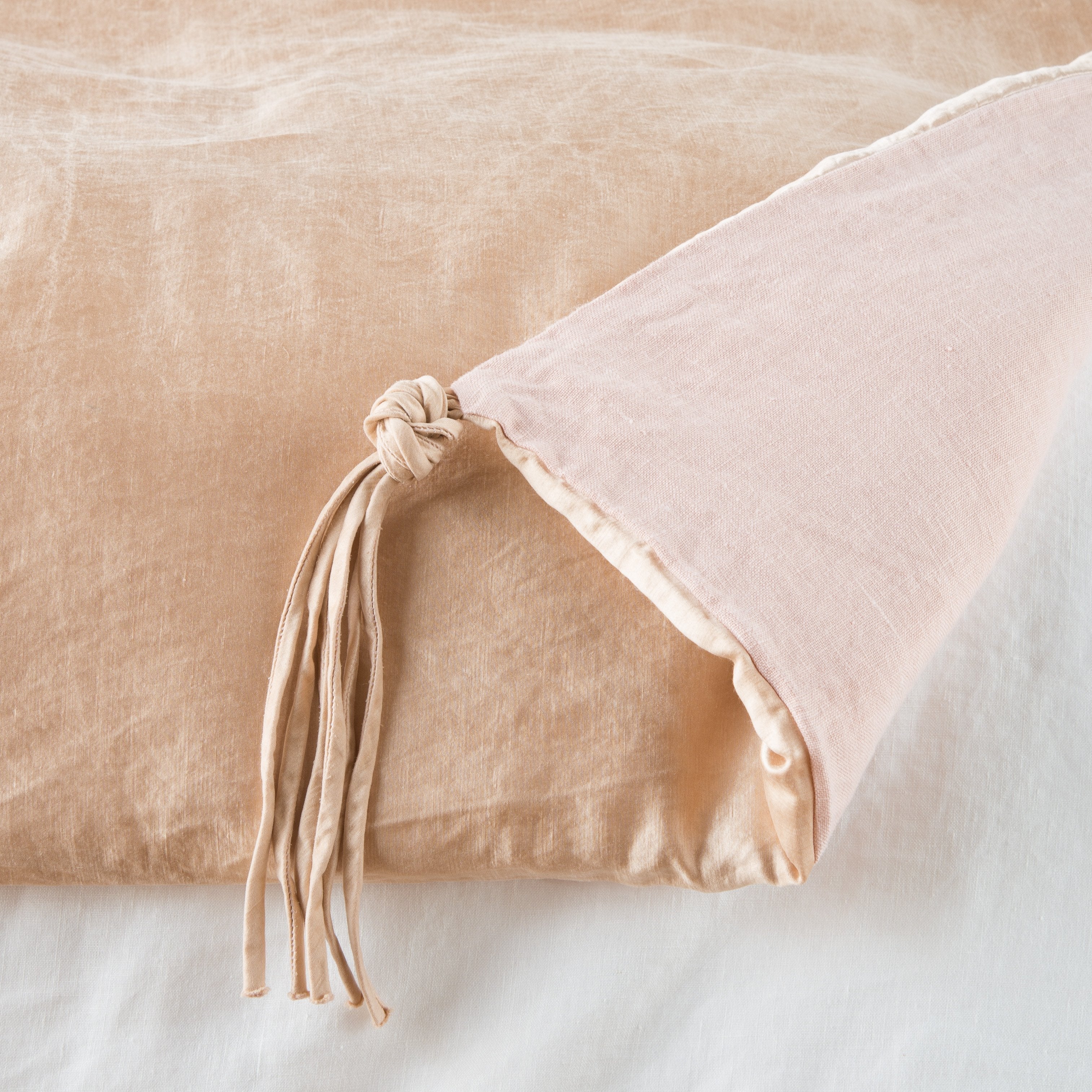 Rouge: Close up of blanket, with a corner turned back to showcase the midweight linen back and corner tassel - overhead view.