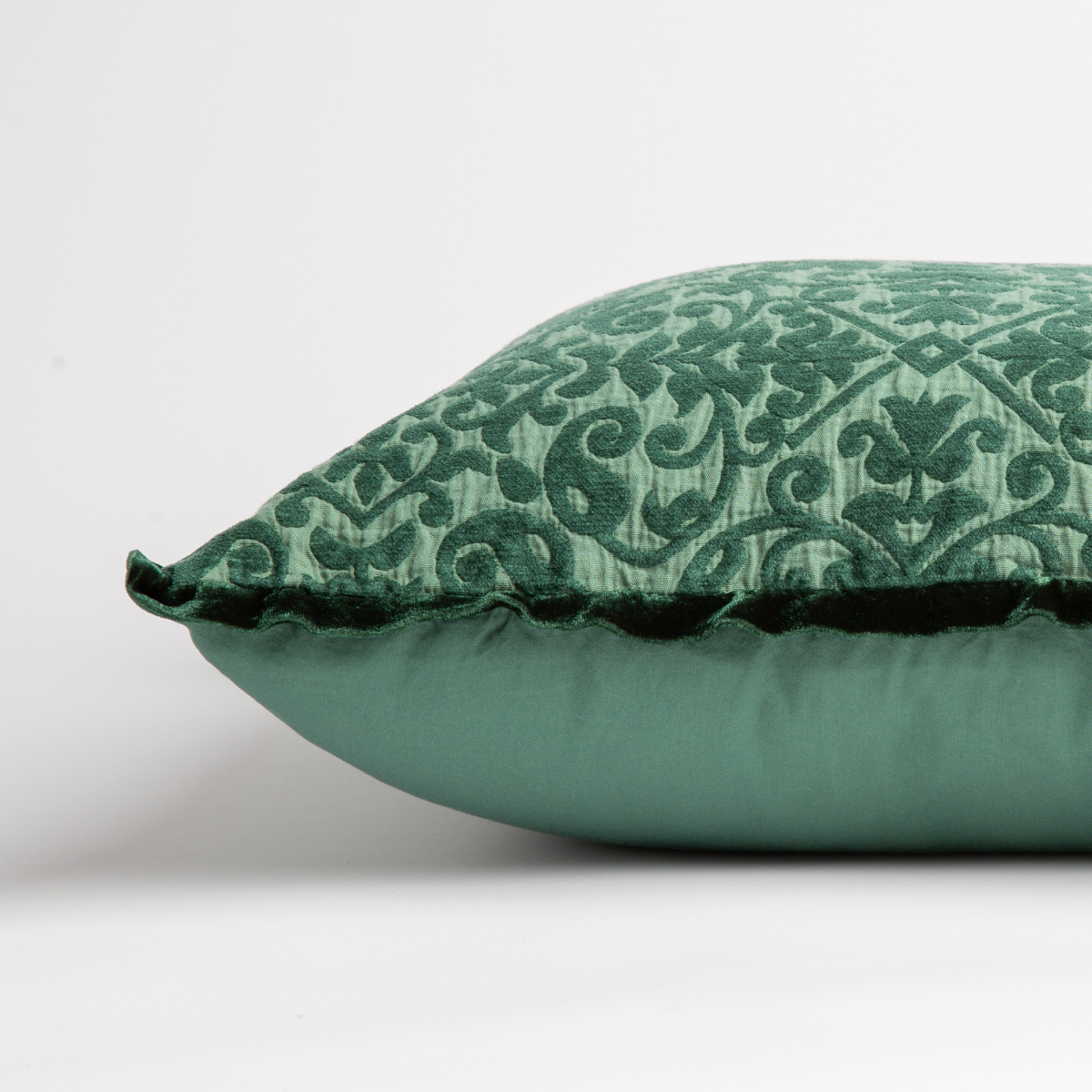 Jade: side view of 18x18 pillow shows cotton sateen back and silk velvet trim detail — close up against a white background. 