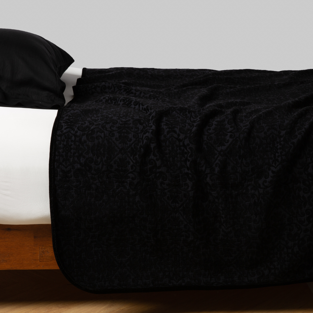 Corvino: coverlet neatly arranged on white sheeting with matching sleeping pillow - side view. 